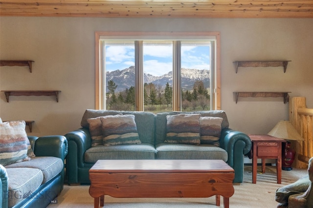 carpeted living room featuring wood ceiling and a mountain view