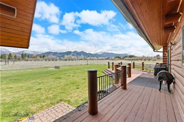 wooden deck featuring a yard, a mountain view, and a rural view