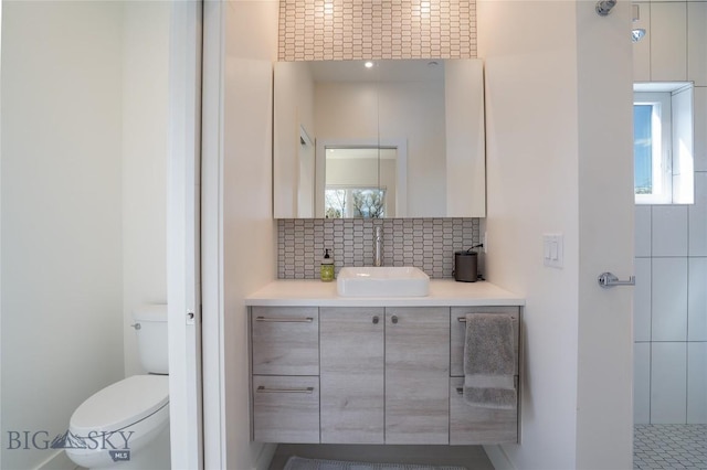 bathroom with vanity, toilet, and backsplash
