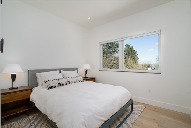 bedroom featuring wood finished floors, baseboards, and recessed lighting