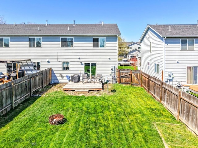 116 Michael Grove Ave, Bozeman, MT 59718 - back of property with a lawn, a wooden deck, a fire pit, and a fenced backyard