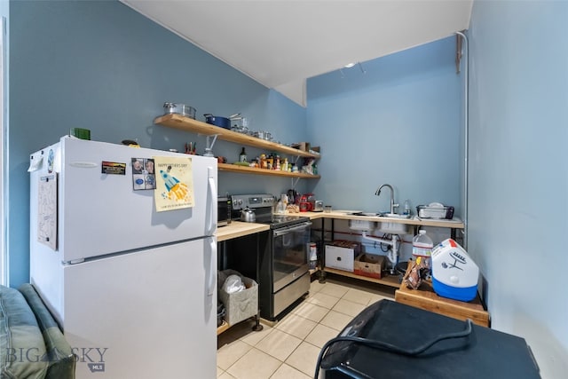 502 W Front St, Livingston, MT 59047 - kitchen featuring freestanding refrigerator, light tile patterned floors, a sink, stainless steel range with electric stovetop, and light countertops