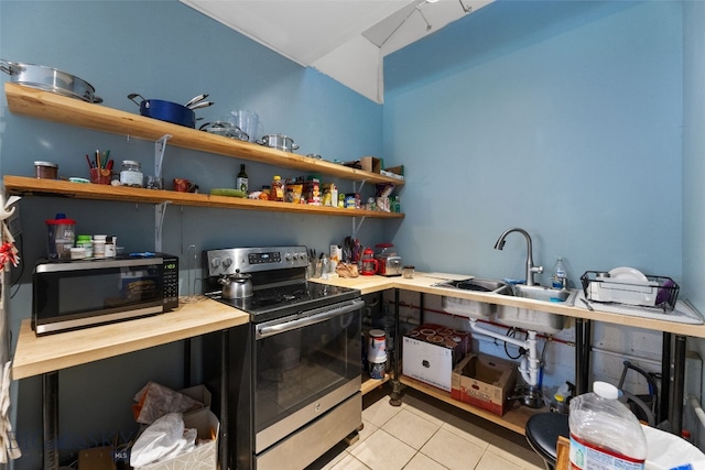 502 W Front St, Livingston, MT 59047 - kitchen with open shelves, stainless steel range with electric cooktop, butcher block counters, and light tile patterned floors