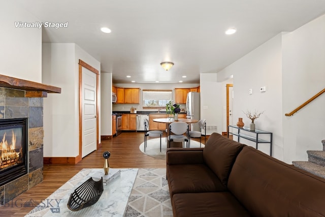 3598 Annie St, Bozeman, MT 59718 - living room featuring a fireplace, stairs, dark wood-style flooring, baseboards, and recessed lighting