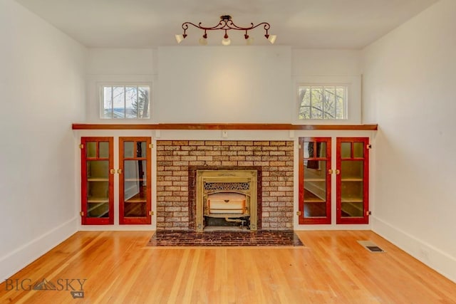 unfurnished living room with baseboards, plenty of natural light, and wood finished floors