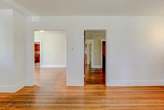 empty room featuring baseboards and light wood finished floors