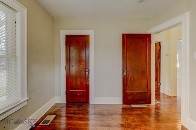 unfurnished bedroom featuring visible vents, wood finished floors, and baseboards