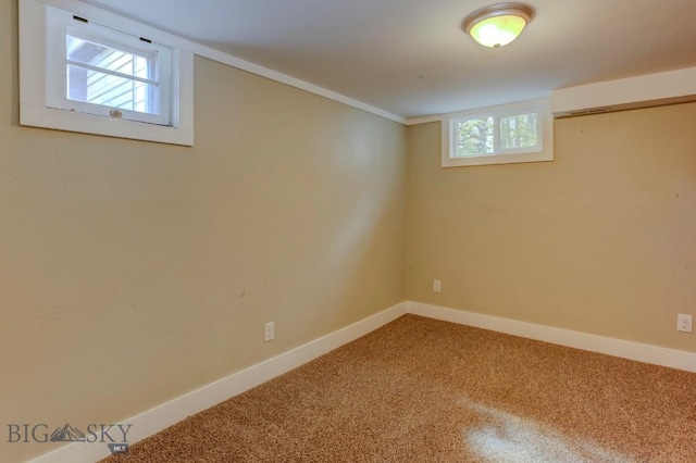 below grade area featuring carpet, baseboards, and a wealth of natural light