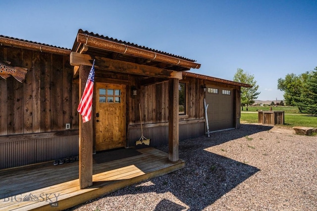exterior space with metal roof, a garage, and driveway