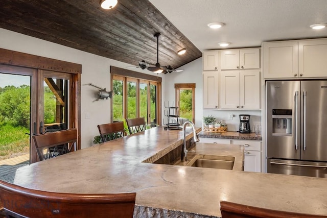 kitchen featuring a sink, high end fridge, recessed lighting, ceiling fan, and white cabinetry