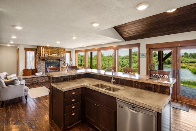 kitchen featuring dark wood-style flooring, open floor plan, a sink, and stainless steel dishwasher