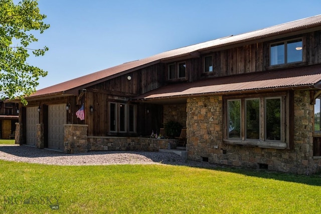 rear view of house featuring stone siding, a garage, crawl space, metal roof, and a yard