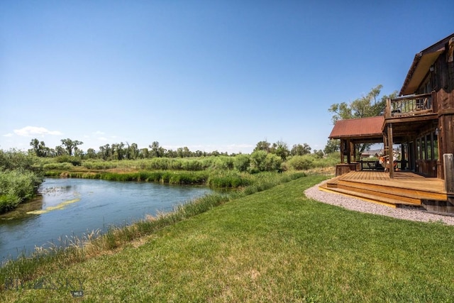 view of yard with a deck with water view
