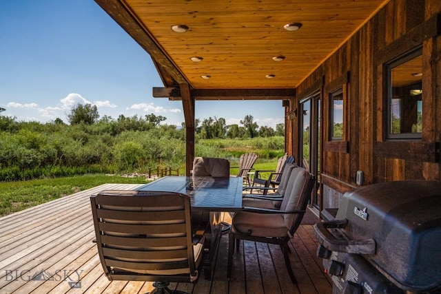 deck with outdoor dining area and a grill