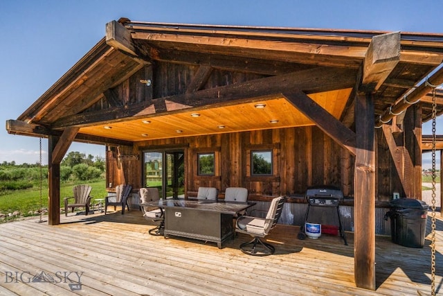 wooden terrace with outdoor dining area and area for grilling