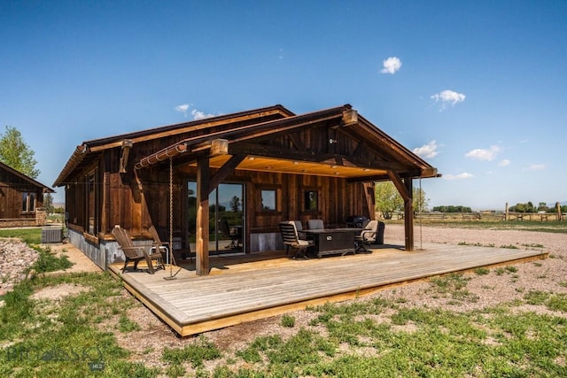 rear view of house with a wooden deck and cooling unit