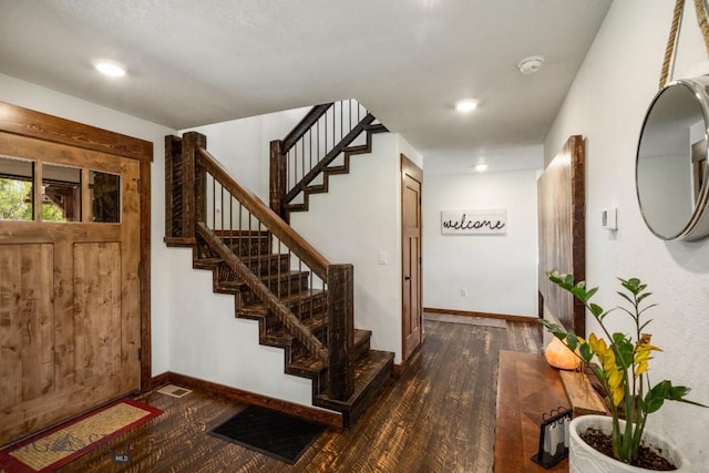 foyer entrance featuring stairway, dark wood-style flooring, baseboards, and recessed lighting