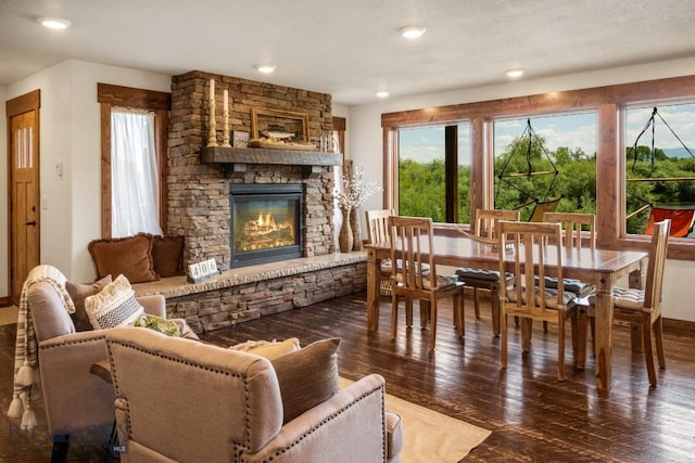 living area with a stone fireplace, baseboards, hardwood / wood-style floors, and recessed lighting