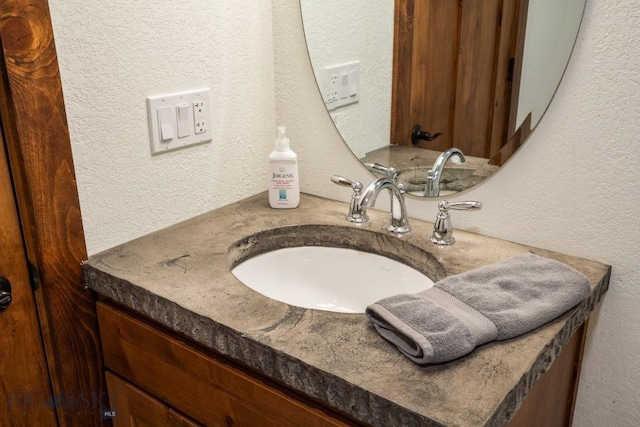 bathroom featuring vanity and a textured wall
