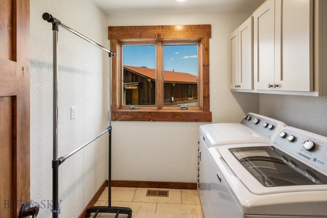 laundry area featuring washer and clothes dryer, cabinet space, baseboards, and visible vents