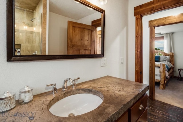 ensuite bathroom featuring ensuite bathroom, vanity, and a tile shower