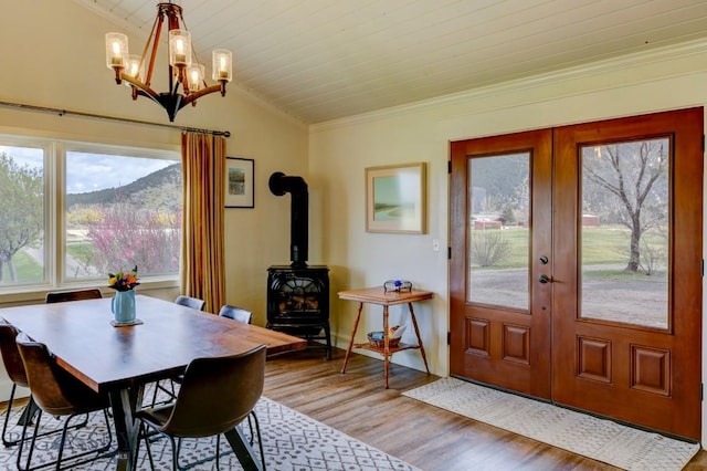 dining space with ornamental molding, french doors, light wood-type flooring, and vaulted ceiling