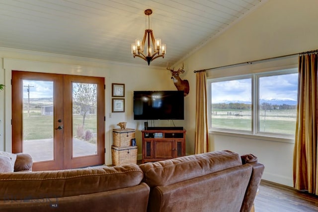 living area with french doors, wood finished floors, a chandelier, crown molding, and baseboards