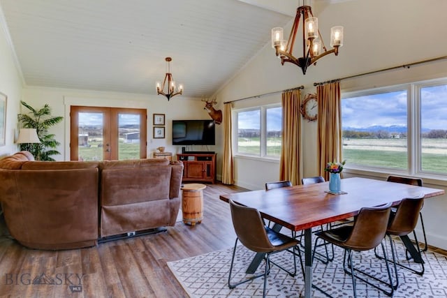 dining space with french doors, wood finished floors, high vaulted ceiling, a chandelier, and baseboards