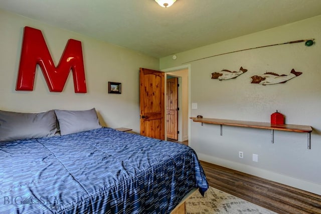 bedroom with baseboards and wood finished floors