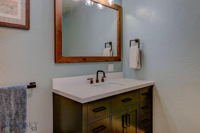 bathroom featuring vanity and a textured wall