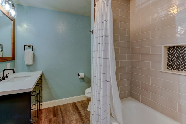 full bathroom with toilet, wood finished floors, shower / tub combo with curtain, baseboards, and vanity