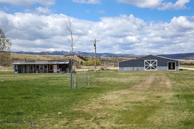 view of yard with a mountain view, an outbuilding, a barn, and a rural view