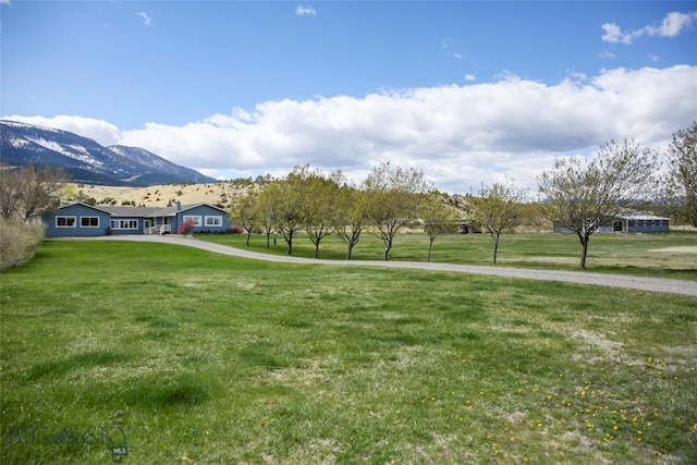 surrounding community with a mountain view and a yard