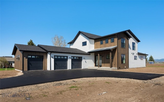 5680 Staffanson Rd, Bozeman, MT 59718 - modern farmhouse style home with a garage, board and batten siding, and asphalt driveway