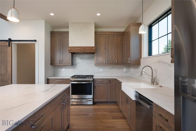 5680 Staffanson Rd, Bozeman, MT 59718 - kitchen with stainless steel appliances, a sink, custom range hood, dark wood-style flooring, and light stone countertops