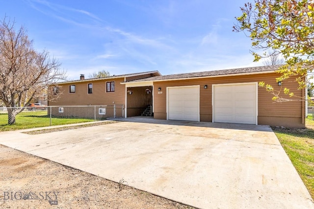split level home with driveway, fence, and a garage