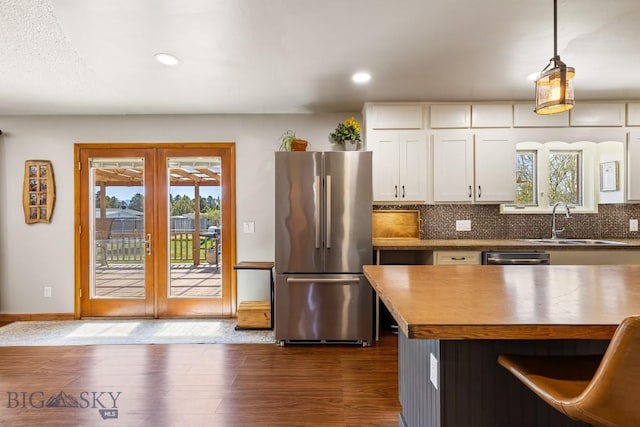 kitchen featuring a sink, french doors, dark wood-style flooring, backsplash, and appliances with stainless steel finishes