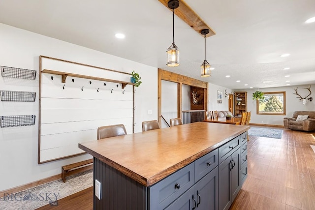 kitchen featuring hanging light fixtures, open floor plan, recessed lighting, and a kitchen island