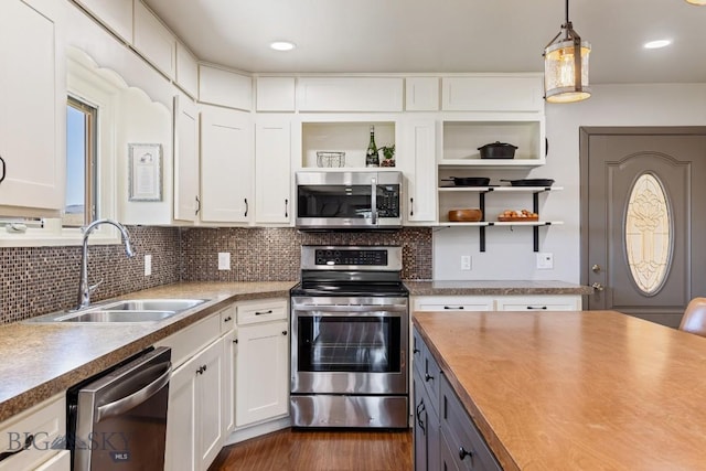kitchen with a sink, white cabinets, open shelves, stainless steel appliances, and tasteful backsplash
