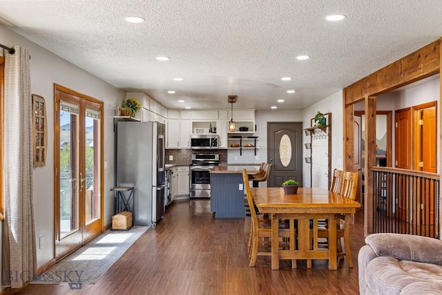 dining space featuring a textured ceiling, recessed lighting, and dark wood finished floors