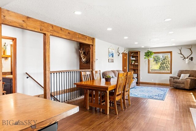 dining area featuring baseboards, recessed lighting, a textured ceiling, and wood finished floors