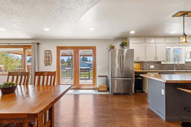 kitchen featuring freestanding refrigerator, recessed lighting, white cabinets, and a sink