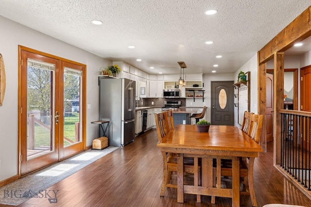 dining room with dark wood finished floors, french doors, recessed lighting, and a textured ceiling