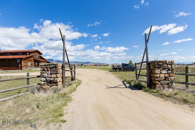 2 Dayspring Rd W, Sheridan, MT 59749 - view of dirt / gravel road featuring a view of rural / pastoral area, a gated entry, a mountain view, and an exterior structure
