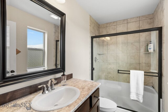 bathroom with a shower with door, toilet, and vanity