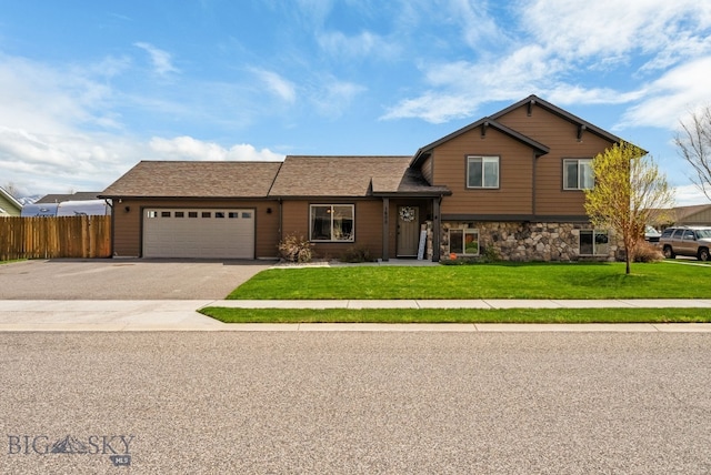 split level home with an attached garage, driveway, and stone siding