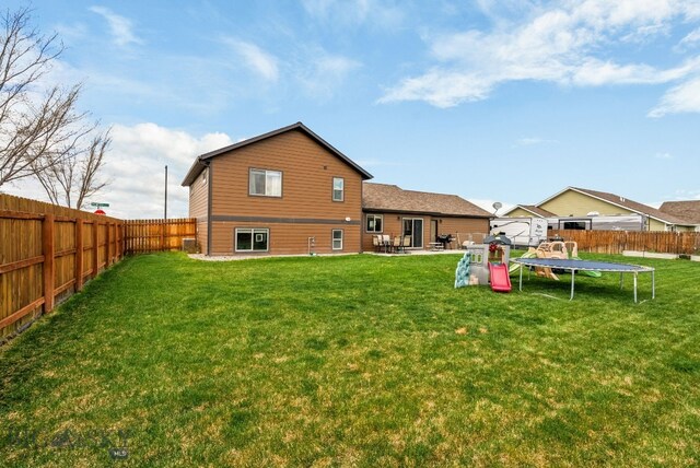 rear view of house featuring a trampoline and a patio area