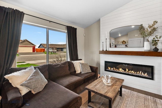 living area with vaulted ceiling, wood finished floors, and a fireplace