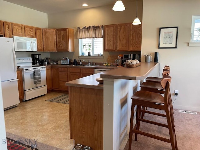 4277 W Babcock St Unit 6, Bozeman, MT 59718 - kitchen with white appliances, a peninsula, a kitchen breakfast bar, plenty of natural light, and recessed lighting