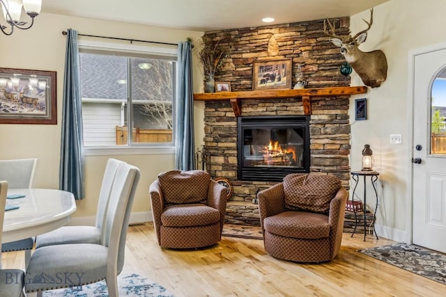 304 Farmall Ln, Manhattan, MT 59741 - living area with wood finished floors, a fireplace, baseboards, and a chandelier